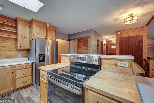 kitchen with butcher block counters, stainless steel appliances, a textured ceiling, light wood-type flooring, and light brown cabinets