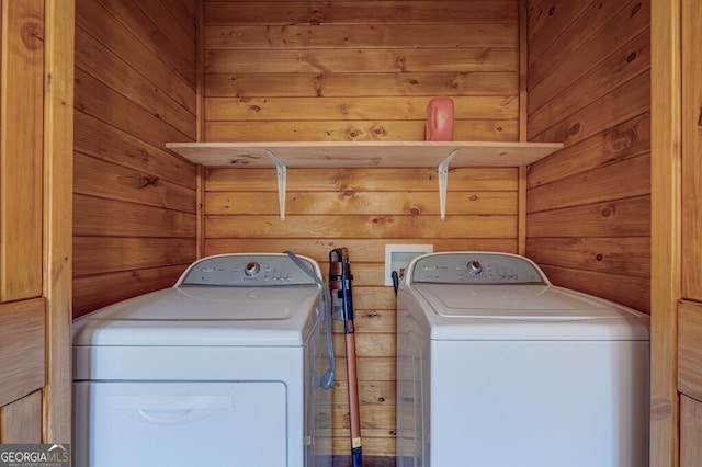 washroom featuring washer and dryer and wood walls