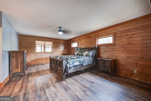 bedroom with dark hardwood / wood-style flooring, ceiling fan, and a textured ceiling