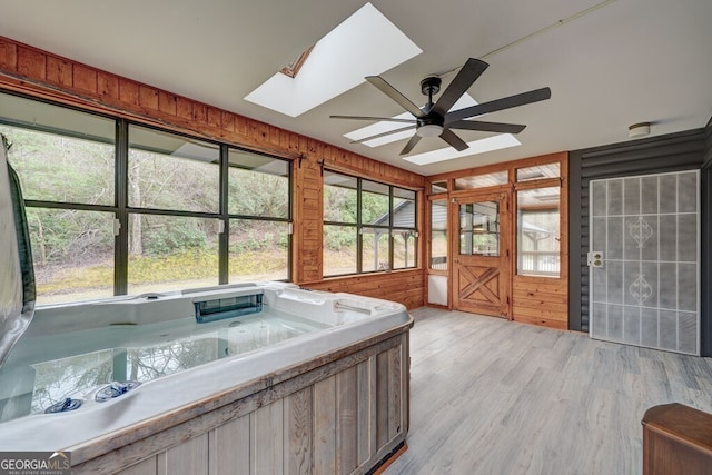 unfurnished sunroom featuring a jacuzzi and a skylight