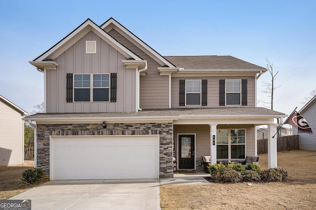 craftsman inspired home with fence, stone siding, concrete driveway, board and batten siding, and a garage