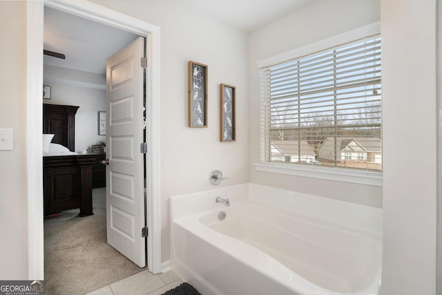 ensuite bathroom featuring connected bathroom, a garden tub, and tile patterned floors