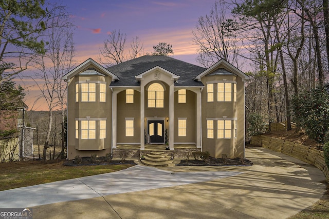 view of front of house with roof with shingles and stucco siding