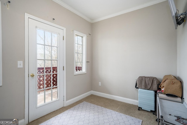 entryway with a healthy amount of sunlight, light colored carpet, crown molding, and baseboards