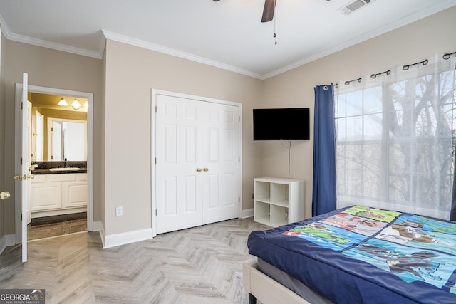 bedroom with baseboards, visible vents, a sink, crown molding, and a closet