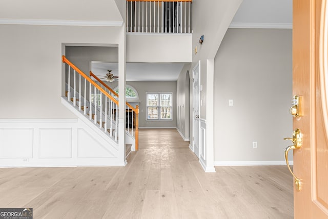 entrance foyer with light hardwood / wood-style flooring, ornamental molding, and ceiling fan