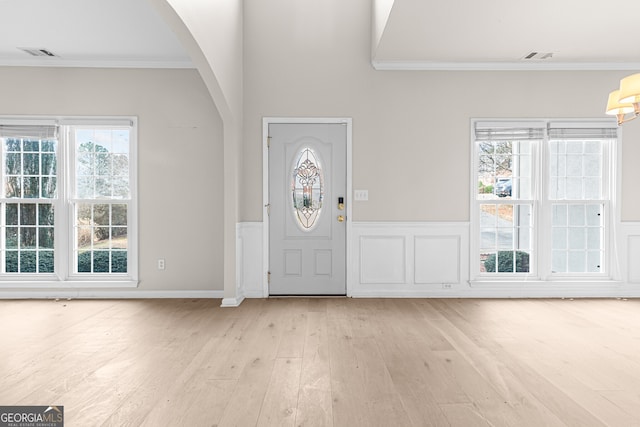 entrance foyer with light hardwood / wood-style flooring and ornamental molding