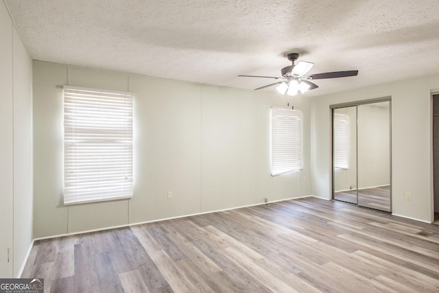 spare room featuring ceiling fan, a textured ceiling, and light hardwood / wood-style flooring