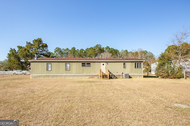 rear view of house featuring a yard and central AC unit