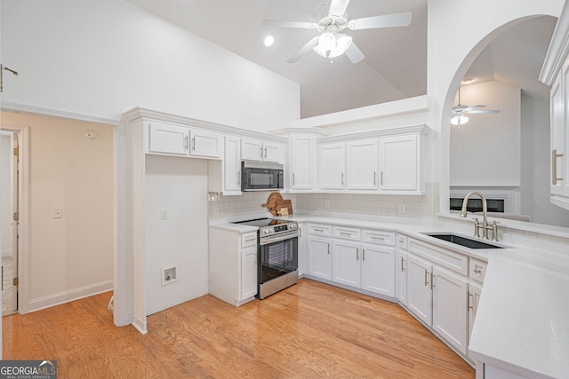 kitchen with sink, backsplash, light wood-type flooring, white cabinetry, and stainless steel electric stove