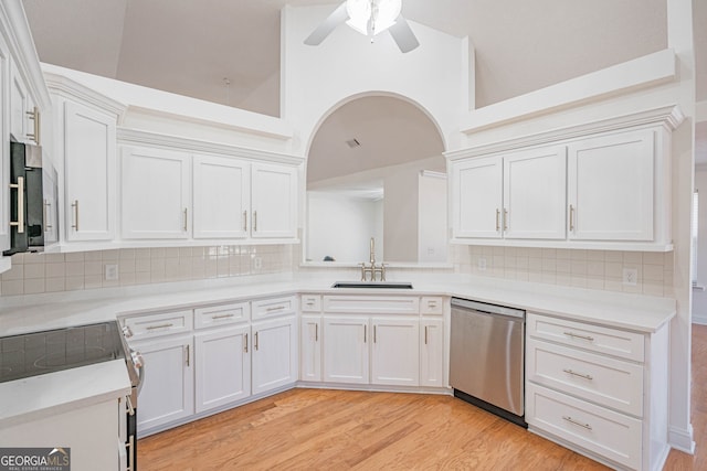 kitchen with white cabinetry, light wood-type flooring, sink, appliances with stainless steel finishes, and decorative backsplash