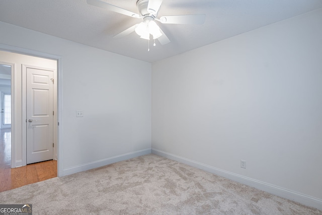 carpeted spare room with ceiling fan