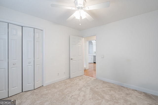 unfurnished bedroom with ceiling fan, a closet, and light colored carpet