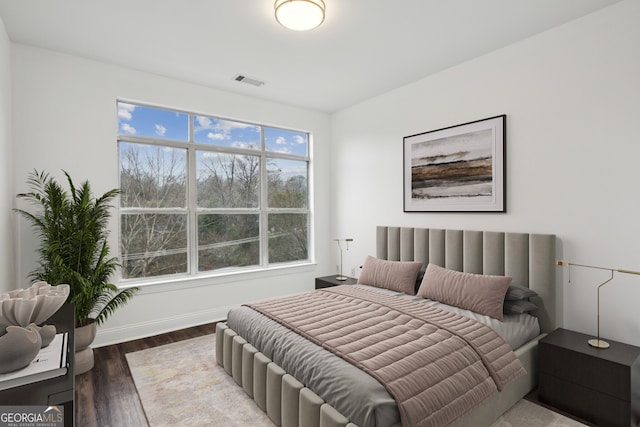 bedroom with dark hardwood / wood-style flooring