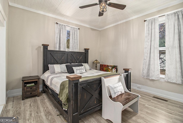 bedroom featuring light wood-type flooring, visible vents, and crown molding