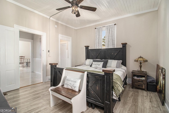 bedroom featuring light wood-type flooring, wooden ceiling, ceiling fan, and ornamental molding