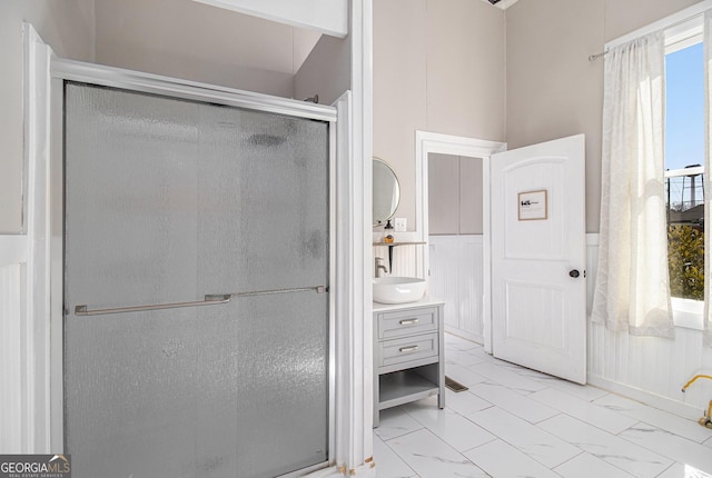 full bath with marble finish floor, a shower stall, and vanity