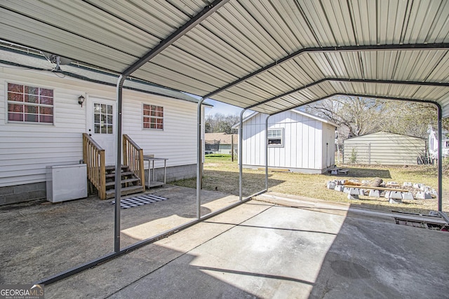 view of patio with an outbuilding, a detached carport, and entry steps