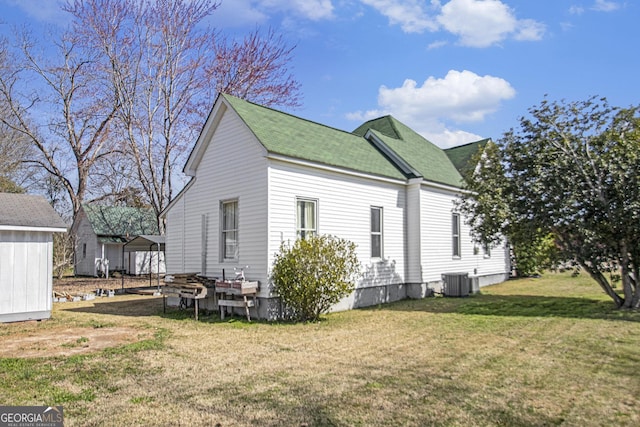 view of property exterior featuring central AC unit and a lawn