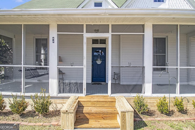 property entrance with a porch and roof with shingles