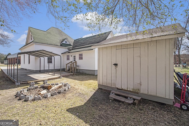 back of property with a storage shed, an outdoor structure, and entry steps