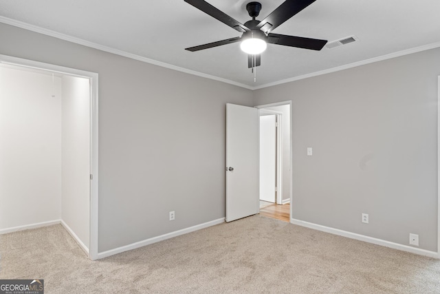 unfurnished bedroom with ceiling fan, light carpet, visible vents, baseboards, and crown molding