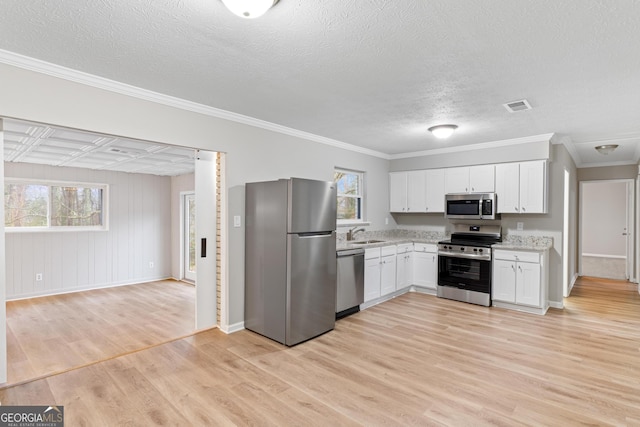 kitchen with sink, plenty of natural light, appliances with stainless steel finishes, light hardwood / wood-style floors, and white cabinets