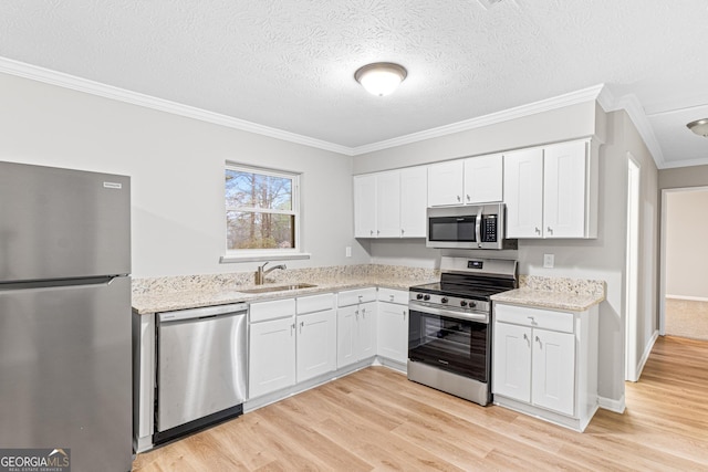 kitchen with light wood-style floors, white cabinetry, stainless steel appliances, and a sink