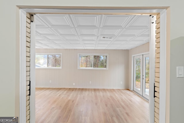 empty room with baseboards, visible vents, an ornate ceiling, and light wood-style floors