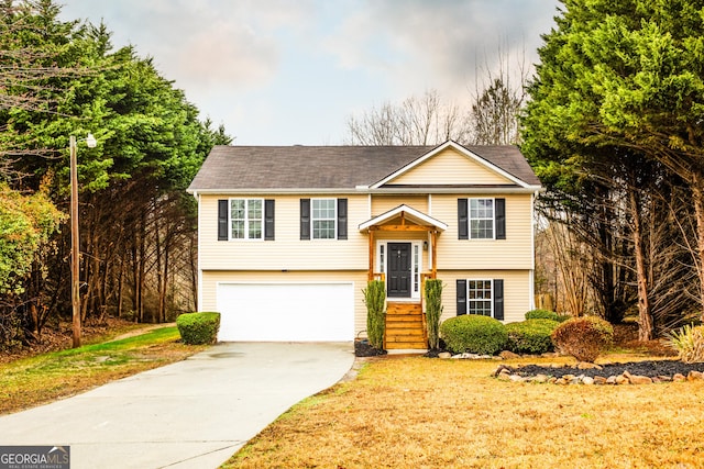 raised ranch with a garage and a front lawn