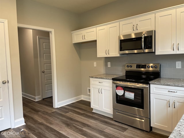 kitchen with stainless steel appliances, dark wood-style flooring, backsplash, and white cabinetry