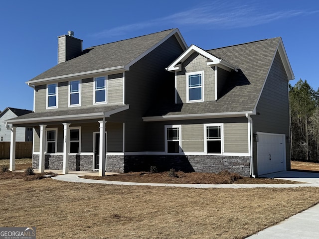 view of front of house featuring a garage, concrete driveway, stone siding, a chimney, and a porch