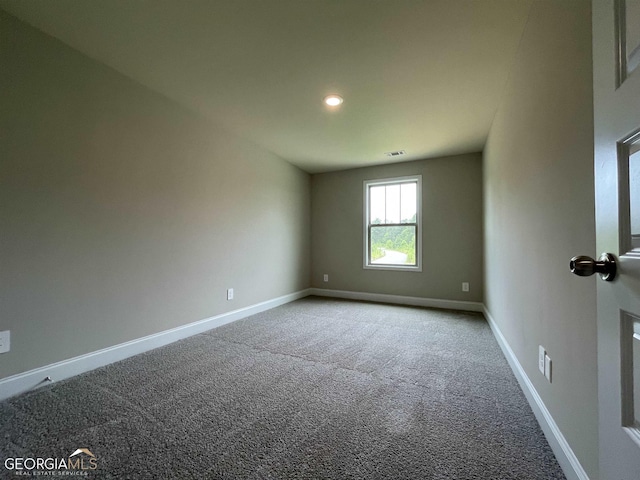 unfurnished room featuring carpet flooring, visible vents, and baseboards