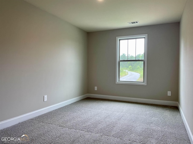 spare room featuring visible vents, baseboards, and carpet flooring