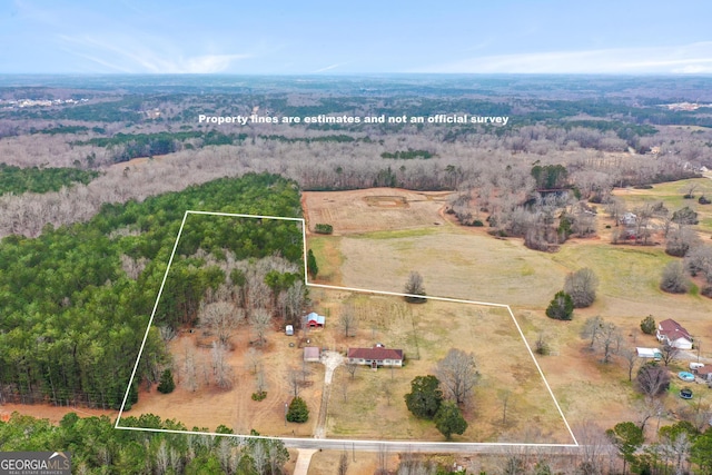 aerial view featuring a wooded view and a rural view