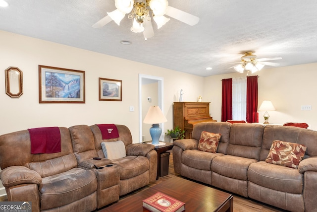 living area featuring a ceiling fan, a textured ceiling, and wood finished floors