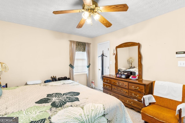 carpeted bedroom with ceiling fan and a textured ceiling