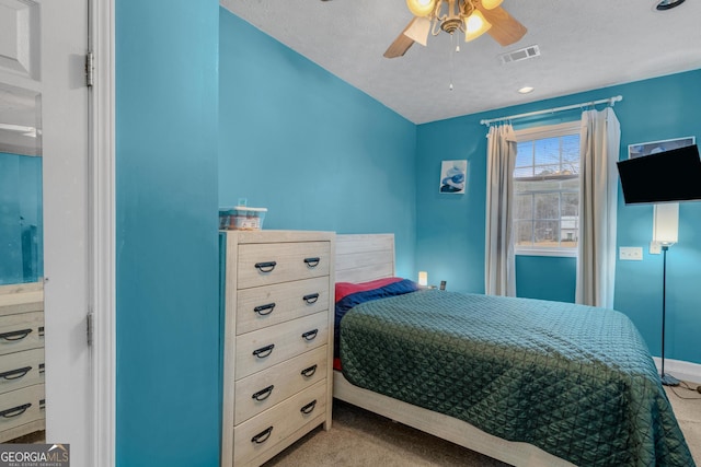 bedroom with baseboards, visible vents, ceiling fan, a textured ceiling, and carpet flooring