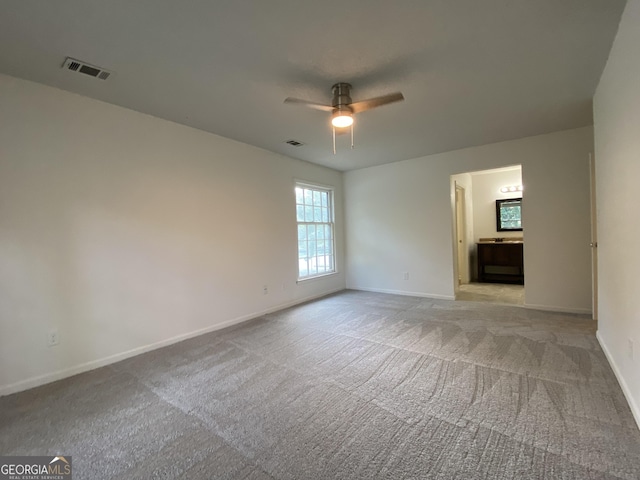 carpeted spare room with ceiling fan