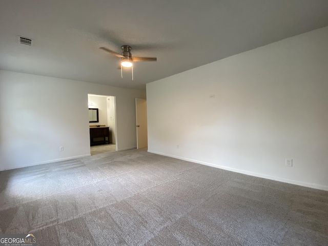 empty room featuring ceiling fan and carpet