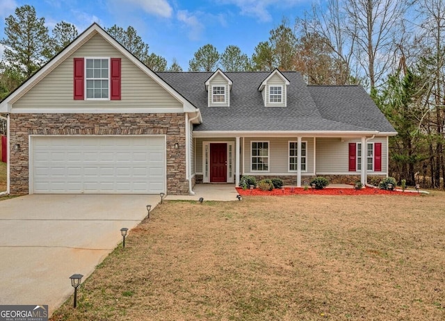 view of front facade featuring a garage, a front yard, and covered porch