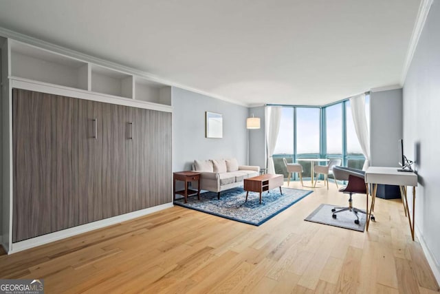 living room with crown molding, light hardwood / wood-style flooring, floor to ceiling windows, and a water view