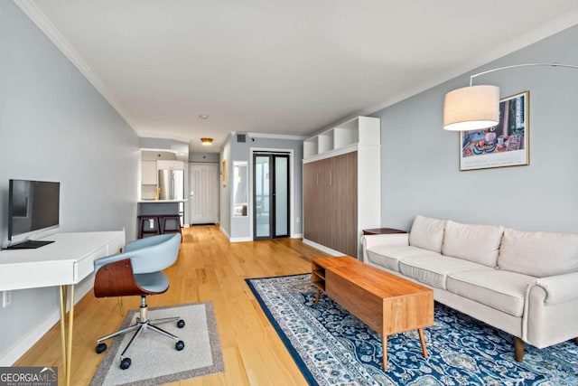 living room featuring ornamental molding and light wood-type flooring