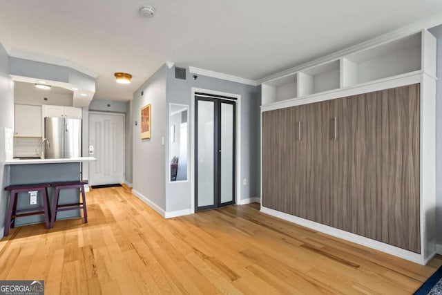 interior space featuring crown molding and light wood-type flooring