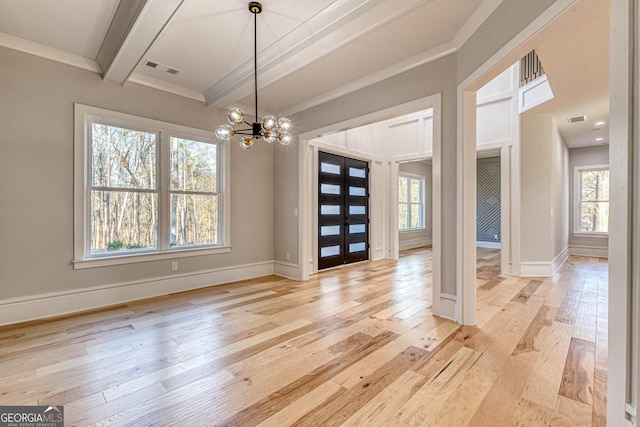 unfurnished dining area featuring beamed ceiling, plenty of natural light, a chandelier, and light hardwood / wood-style floors