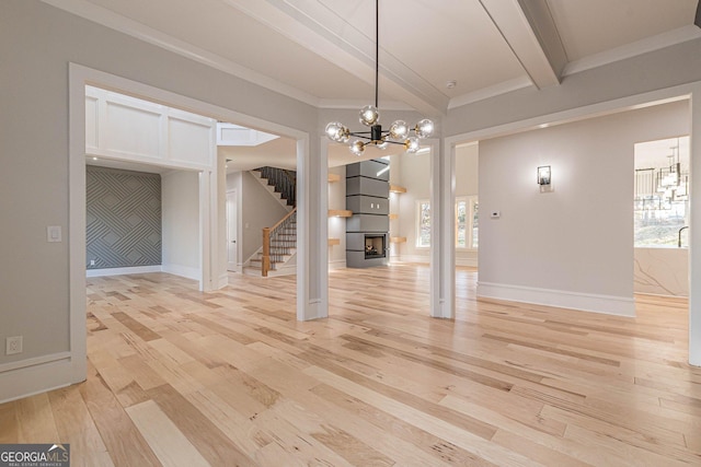 interior space featuring beamed ceiling, crown molding, a chandelier, and light hardwood / wood-style flooring