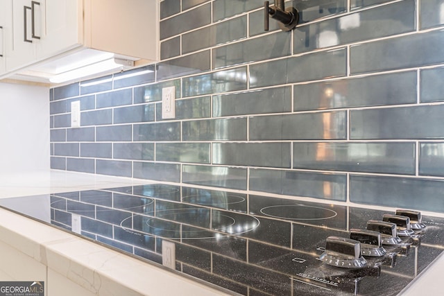 interior details with backsplash and white cabinets