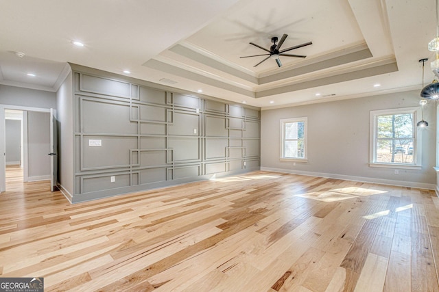 interior space with crown molding, light hardwood / wood-style flooring, ceiling fan, and a tray ceiling