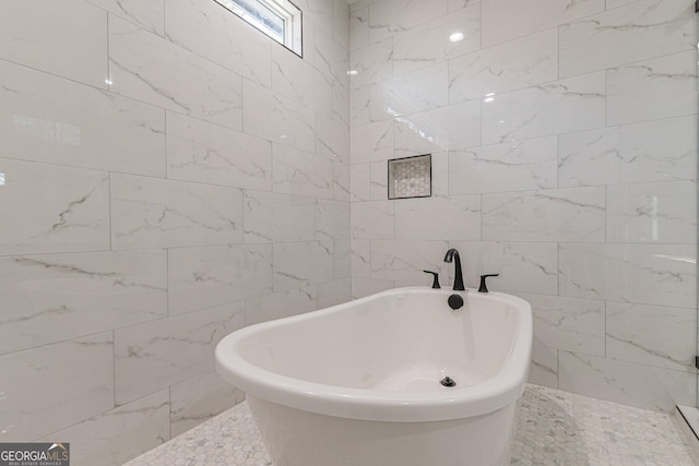 bathroom featuring tile walls and a tub to relax in