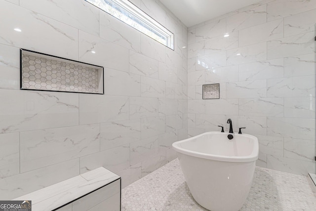 bathroom with tile walls and a tub to relax in